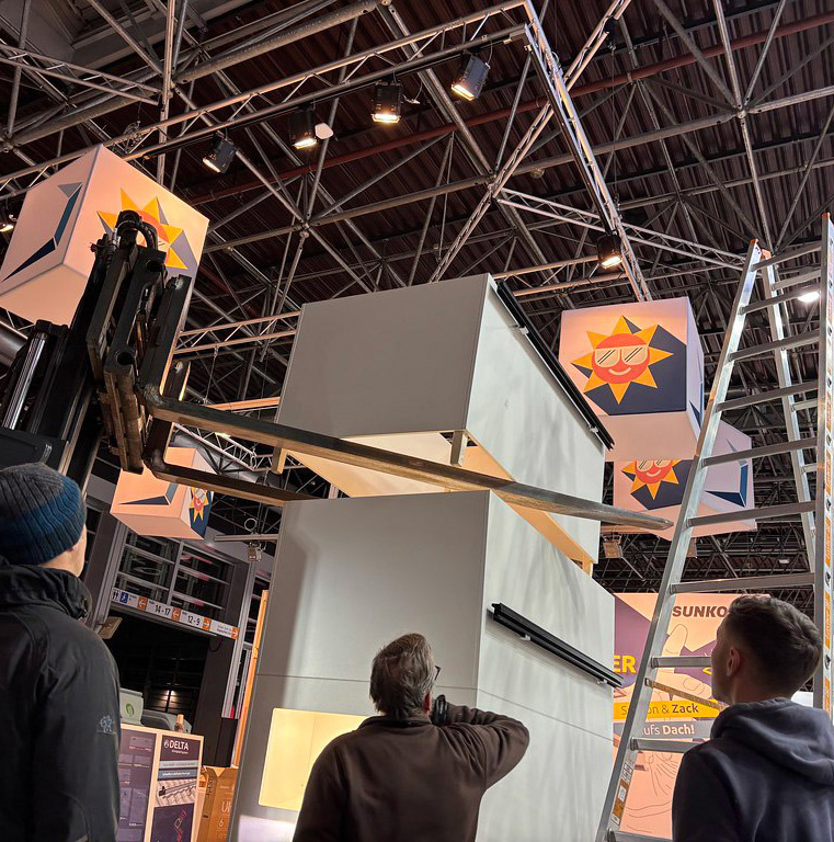 SUNKON Messestand im Aufbau – Montage mit Hubgerät in der Messehalle